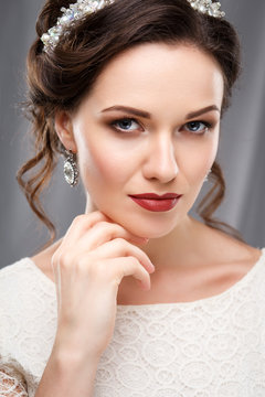 Elegant young woman with perfect makeup and hair style in a white dress. Beauty fashion portrait with accessories