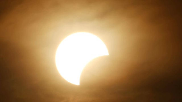 partly solar eclipse when sun rise in Thailand with cloud flow