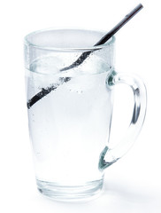 Glass of cold mineral soda water with ice cubes and a cocktail tube isolated on the white background. Mug with crystal clear drinking water, cold and refreshing drink