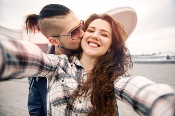 Young and happy couple having fun in the city is photographed