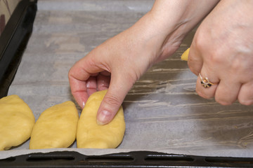 Laying of raw pies with a stuffing on a baking tray