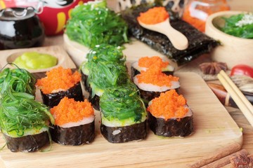 Sushi roll with seaweed salad and shrimp eggs.