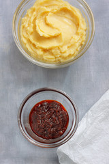 Hummus and harissa sauce on painted textile background