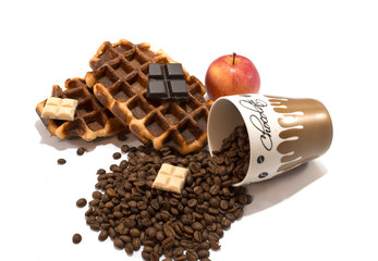 Fresh waffles with cup full of coffee beans and chocolate on whi