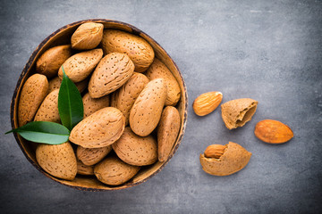 Group of almond nuts with leaves.Wooden background.