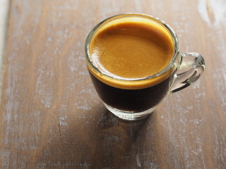 Cup of hot espresso coffee on wood table, background