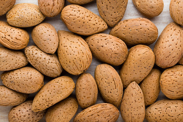 Group of almond nuts with leaves.Wooden background.
