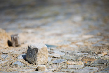 Eine Kleinpflasterfläche ist aufgebrochen, ein Pflasterstein liegt lose herum.