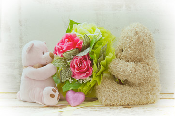 Soft focuscouple of cute bears holding roses bouquet