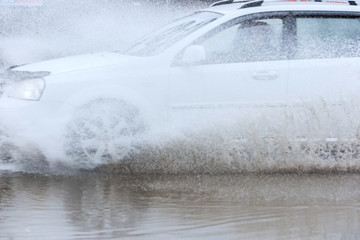 Obraz na płótnie Canvas car rain puddle splashing water