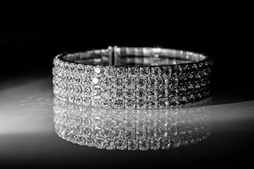 bracelet made of zirconium on a shiny glass surface