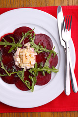 beet salad and cheese and arugula in a white plate