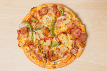 Pizza with sliced vegetables on wood