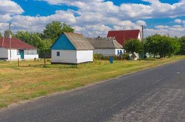 Fototapeta na wymiar Summer landscape with asphalt road through small remote village Stepanivka in Poltavskaya oblast, Ukraine