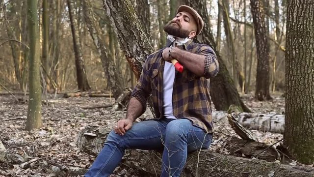 lumberjack in a cap has a shave with an axe