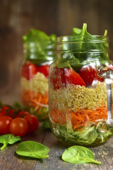 Salad with quinoa and vegetables in a mason jar.