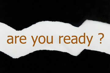 The question Are You Ready appearing behind torn black paper