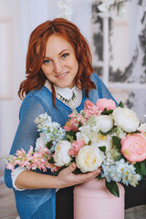 Portrait of young redheaded woman in flowers, fiolet and quartz. Looking at the camera