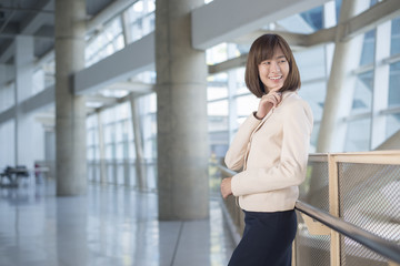 Attractive asian business woman smiling outside office