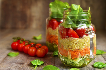 Salad with quinoa and vegetables in a mason jar.