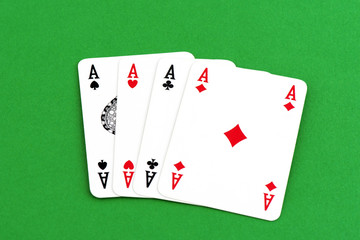 Playing card on green table, four a kind aces