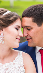 Fototapeta premium Bride and groom at wedding Day walking Outdoors. Happy Newlyweds embracing. Loving couple. 