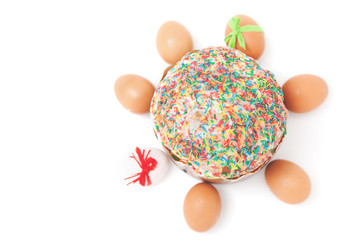 Easter eggs lie around cake on white background