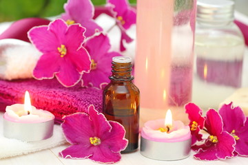 Obraz na płótnie Canvas SPA setting with candles, aroma oil and violets