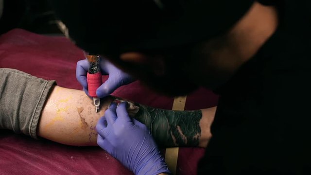 Tattoo master making tattoo. Close up. Slow motion