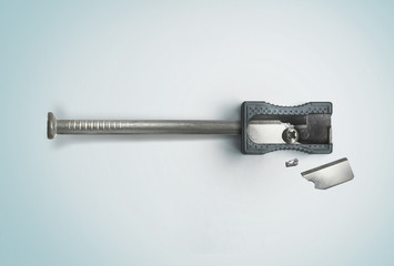 Nail and a broken sharpener. Creative concept. Safety, destruction. Top view