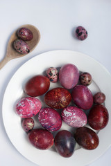 red chicken and quail eggs on white background