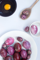 red chicken and quail eggs on white background