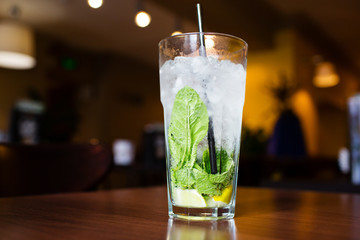 Mahito cocktail with mint on wooden table in restaurant