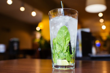 Mahito cocktail with mint on wooden table in restaurant