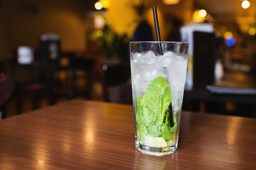 Mahito cocktail with mint on wooden table in restaurant