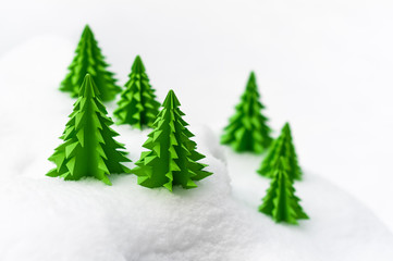 Weihnachtliche Miniaturlandschaft, Frohe Weihnachten, Papiertannenbäume im Schnee, schlichte Weihnachtskarte in Weiß und Grün, plakativ, Textfreiraum, Winterlandschaft