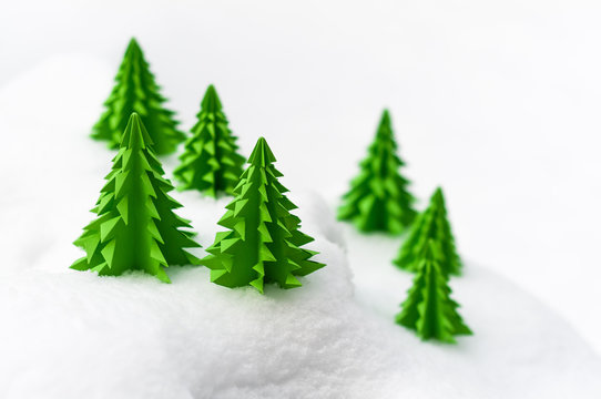 Weihnachtliche Miniaturlandschaft, Frohe Weihnachten, Papiertannenb&auml;ume im Schnee, schlichte Weihnachtskarte in Wei&szlig; und Gr&uuml;n, plakativ, Textfreiraum, Winterlandschaft