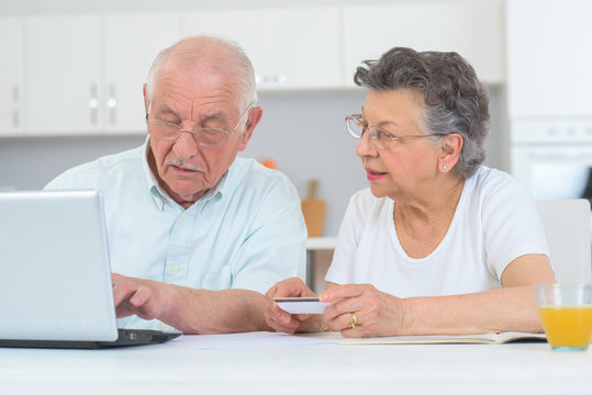 Elderly Couple In Front Of The Laptop At Home