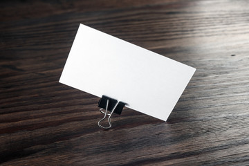 Photo of blank business card on dark wooden background. Mock-up for branding identity. Blank...