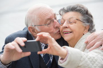 elderly couple taking a selfie