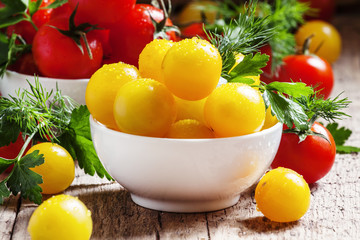 Cherry tomatoes in a porcelain bowl, vintage wooden background,