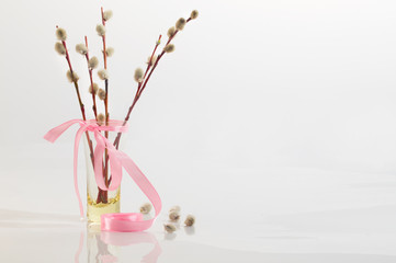 Willow branches with a pink tape in a transparent vase