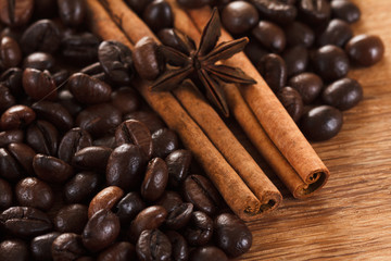 Coffee beans with cinnamon and anise on wooden table 