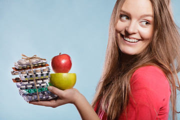 Woman holding pills and fruits. Health care