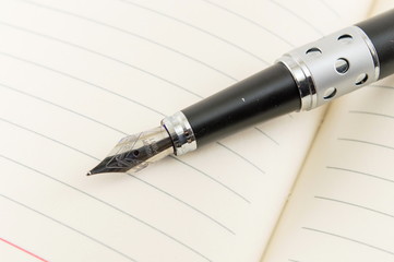 Black fountain pen on a notebook