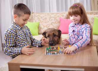 children playing board game ludo at home on the table