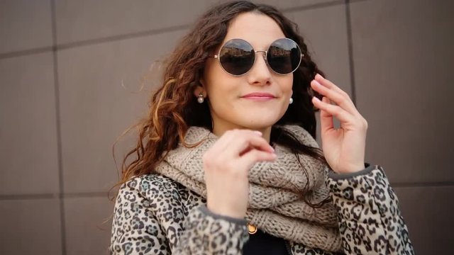 Beautiful young woman wearing her sunglasses on the street.