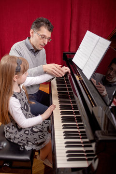 Piano player and his little girl student during lesson