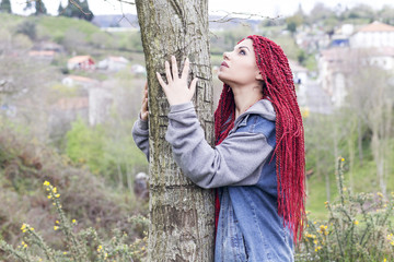 Woman touching a tree, thinking.