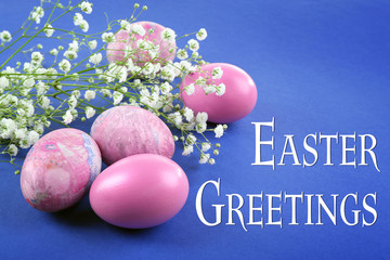 Easter greeting card.  Pink eggs and gypsophila on blue background
